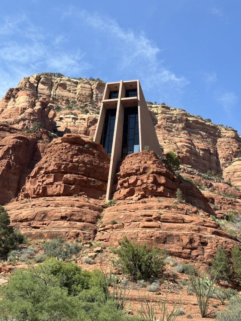 A cross on top of a mountain with trees in the background