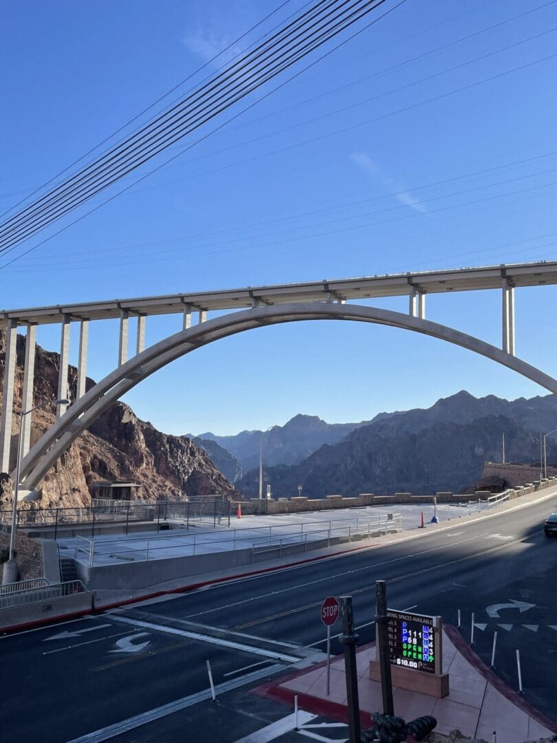 A bridge over the water with mountains in the background.