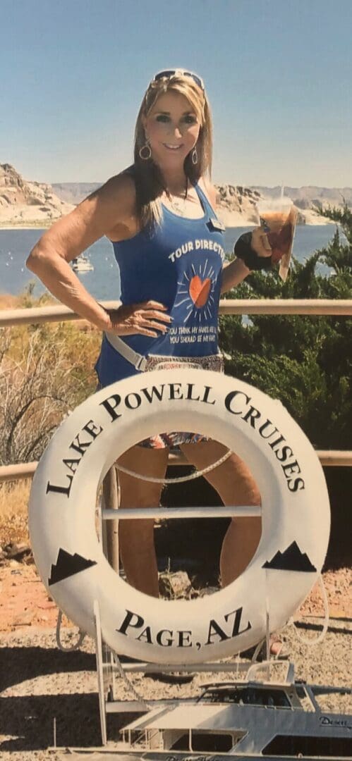 A woman in blue shirt standing next to a lifeguard boat.