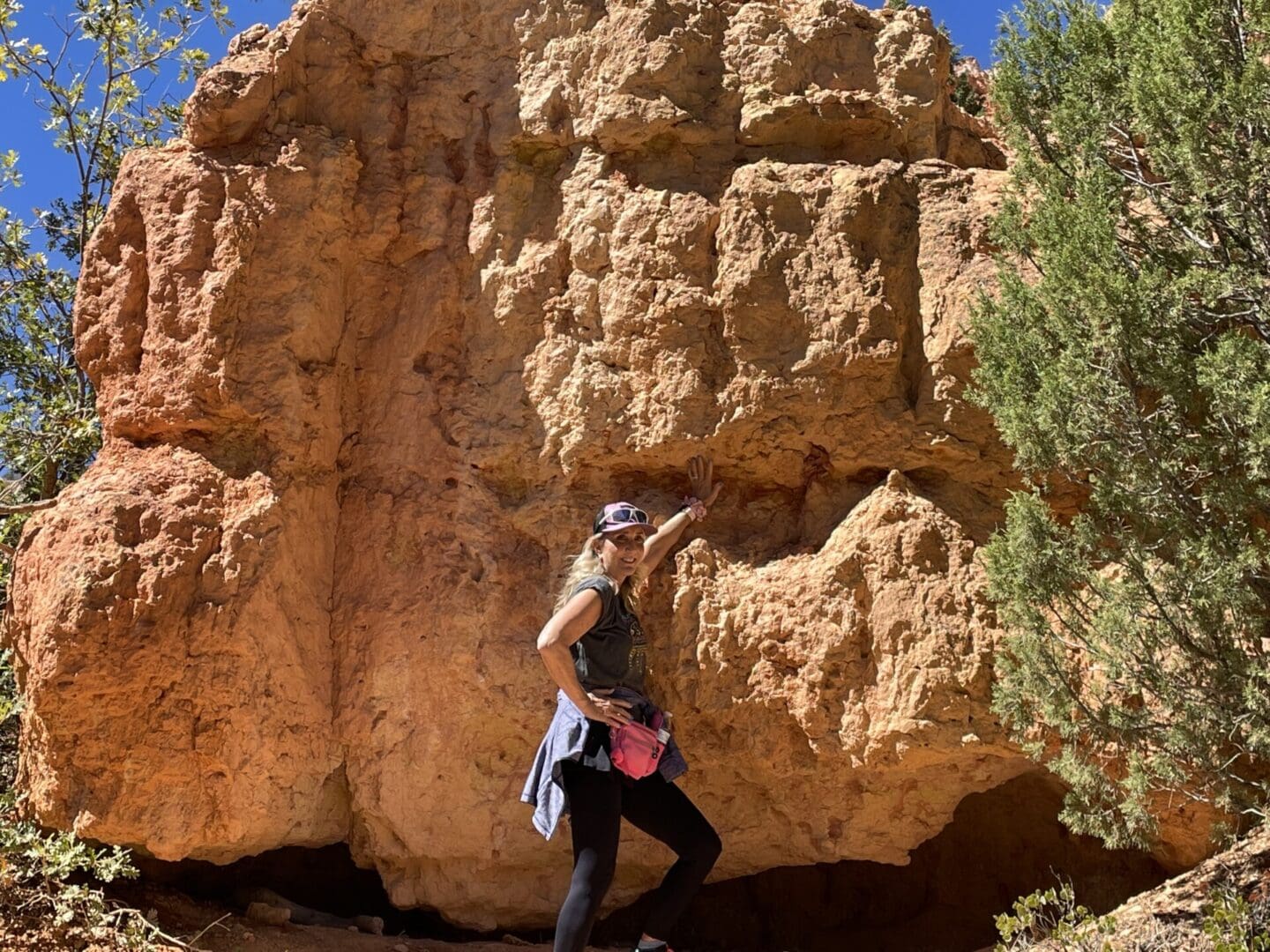 A woman standing in front of a rock formation.