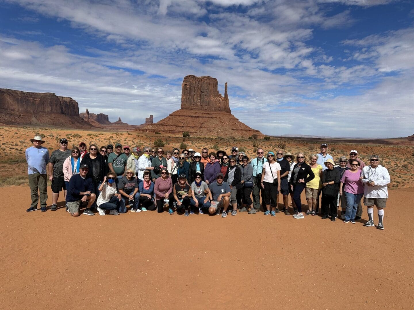 A group of people standing in front of a mountain.