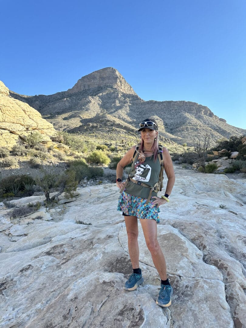 A woman standing on top of a dirt hill.