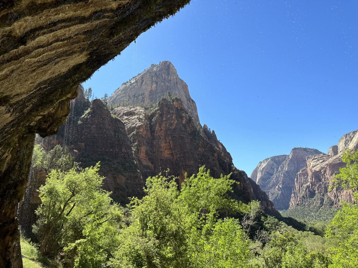 A view of mountains from the side of a cliff.