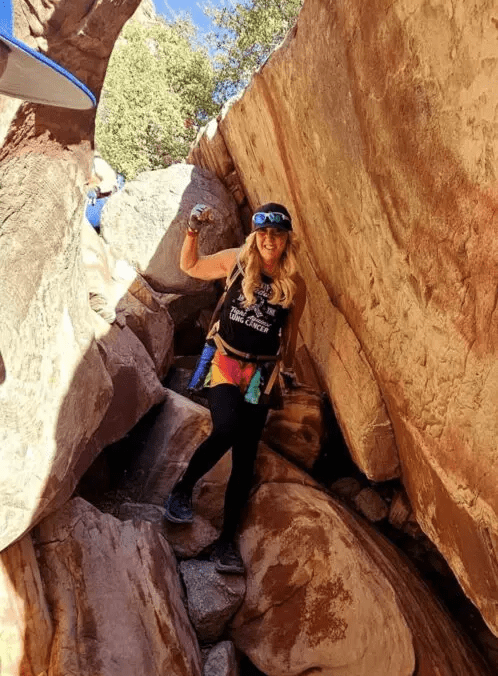 Hiker smiling between rocky canyon walls.
