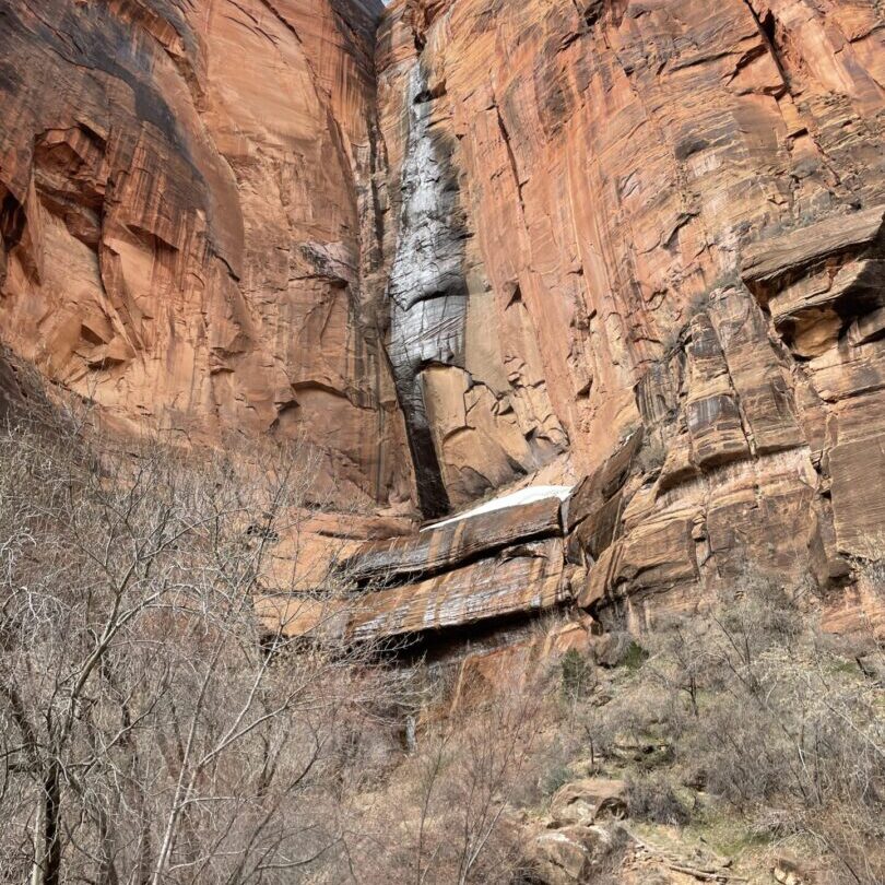 A waterfall is shown on the side of a mountain.